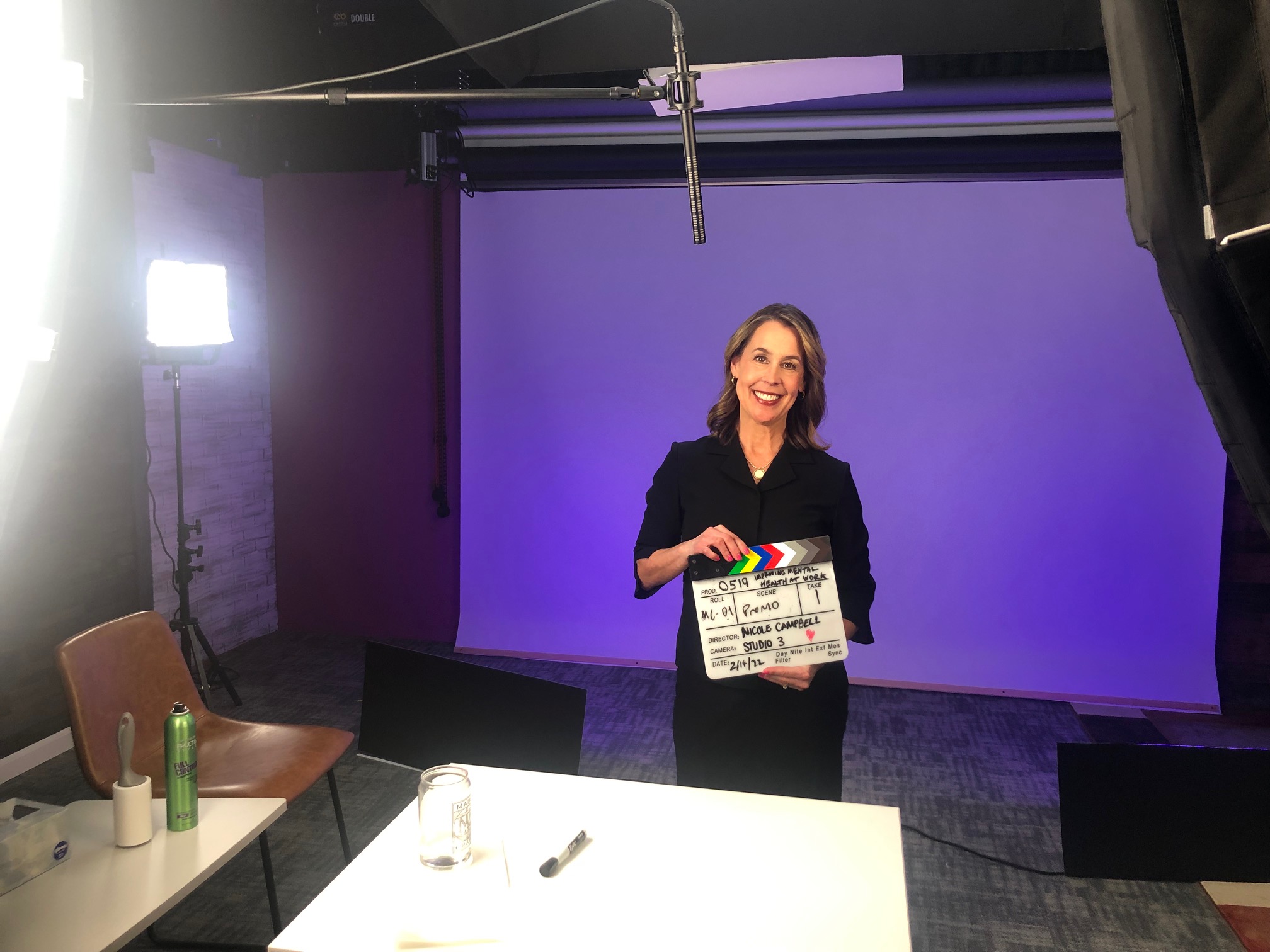 Dr. Karen Doll on set holding a film slate during production of her LinkedIn Learning course